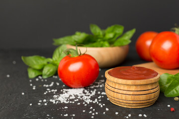 Delicious ketchup with spices and tomatoes on wooden table