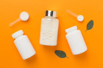 Jars with protein powder on color background, top view. Sports nutrition concept