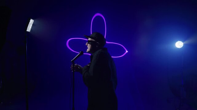 Rap artist singing for a music video behing the scenes