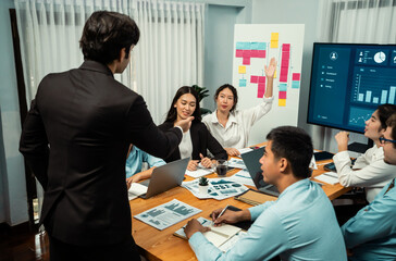 Diverse ethnic group of analyst team actively engage in business meeting, demonstrate their expertise by raise hand, asking insightful questions with TV screen show data analysis dashboard. Habiliment