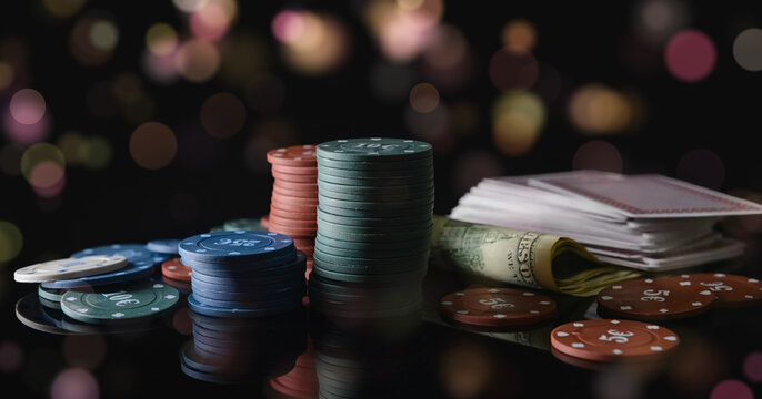 Poker chips, playing cards and dices on dark background