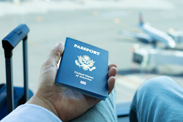Traveler at the airport holding USA passport, holiday, business travel 