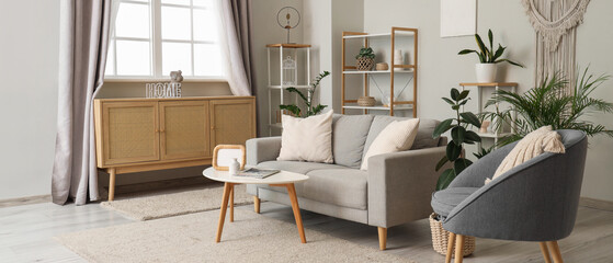Interior of living room with sofa, armchair and curtains on window