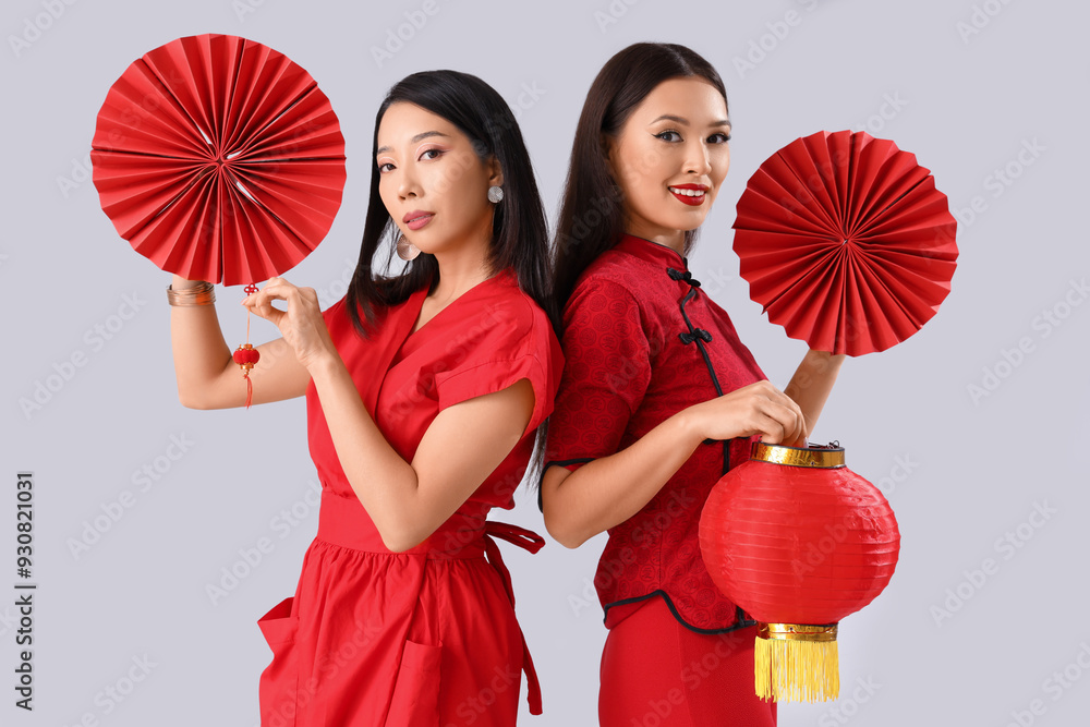 Canvas Prints Young Asian women with fans and lantern on light background. Chinese New Year celebration