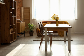 Stylish interior of loft style living room with table, sofa, chairs and shelving unit