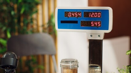 Close up of electronic scale in zero waste supermarket with low carbon dioxide emissions. Panning shot of weighing machine in local grocery store used for bulk products, fruits and vegetables