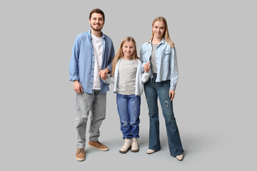 Happy family in stylish denim clothes on grey background