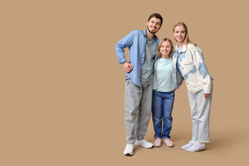 Happy family in stylish denim clothes on brown background