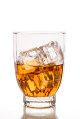 Glass of whiskey with ice cubes on a white background.