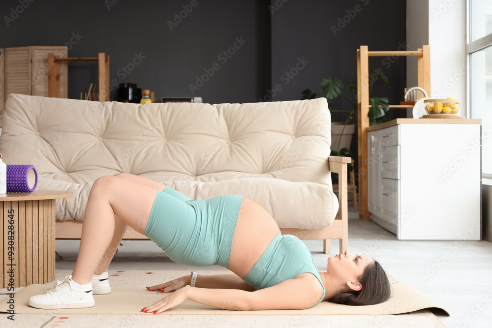 Wall mural sporty pregnant woman training on fitness mat at home