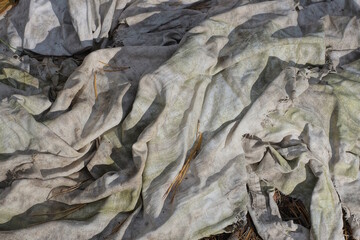 background of a fabric from a piece of crumpled white gray dirty cloth