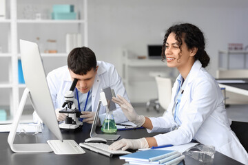 Young chemists working at table in laboratory