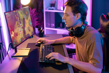 Host channel concentrated smart gaming streamer playing the fighting Moba on computer screen with muptiplayers or single at battle arena . Esport live streaming at neon digital light room. Pecuniary.