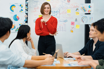 Young beautiful leader presents marketing strategy while expert investor and project manager listening and lecturing to analyze business performance at start up business meeting. Immaculate.
