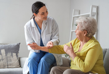 Obraz premium Physical therapist helping senior woman at home