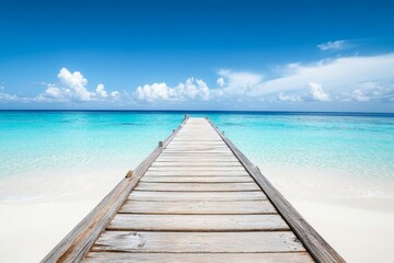 Wooden pier extending into turquoise ocean with white sand beach and clear water in a wide-angle view.