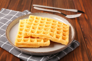 Plate with tasty Belgian waffles on wooden background