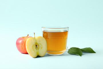 Glass of fresh apple juice on blue background