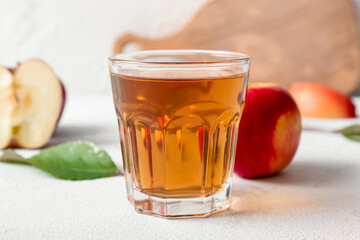 Glass of fresh apple juice on light table