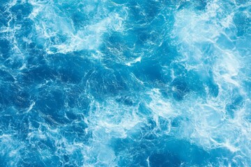 Fototapeta premium Top view of blue ocean water with intricate wave textures and water splashes, creating an abstract background of the sea surface, showcasing the dynamic movement and vibrant blue tones of the ocean.
