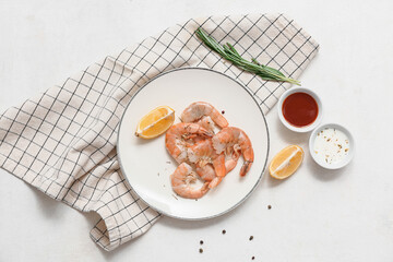 Plate with tasty boiled shrimps and bowls of sauces on white background