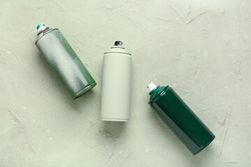 Spray paint cans on green grunge background