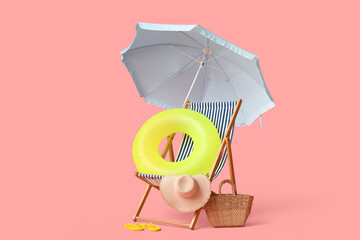 Deck chair, beach umbrella, hat, wicker bag, flip-flops and inflatable ring on pink background