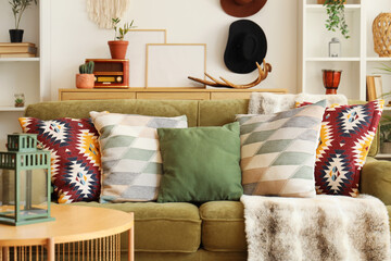 Green sofa with stylish cushions in living room