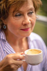 Woman enjoying coffee on a peaceful morning while wearing