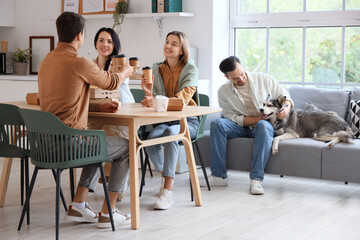 Colleagues with Husky dog during coffee break in office kitchen