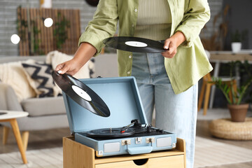 Young woman with vinyl disks for record player at home, closeup