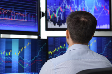 Male trader working in office, back view