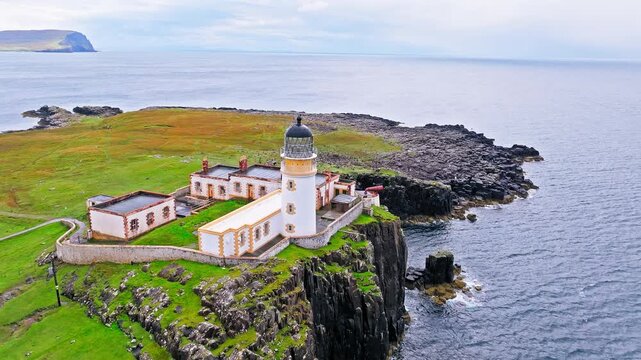 Aerial view of Lighthouse on a rocky cliff-top overlooking a causeway and the coastline in Scotland. Travel destination, tourist attraction landmark of Scottish Neist Point Lighthouse on Isle of Skye.