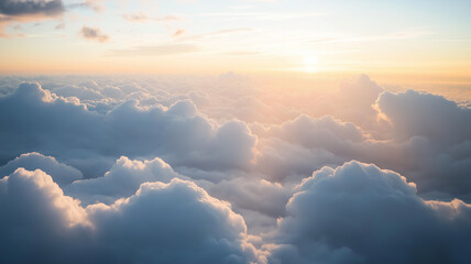 Golden sunset illuminates fluffy cloudscape from above.