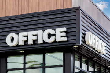 Obraz premium A sign with the bold generic word OFFICE on an industrial metal clad office building