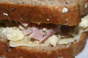 close up of a sandwich. close up of bread. details of the sandwich with ham and cheese. bread with cheese and ham. sandwich with selective focus. sandwich background.