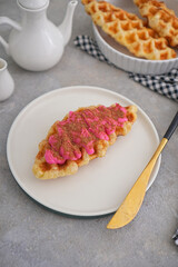 croffle snack food with various toppings, gray background