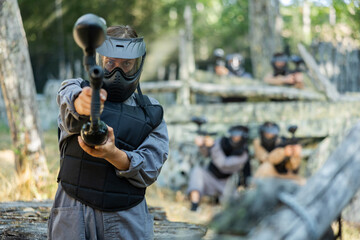Fototapeta premium Paintball player recklessly aims with a gun on the battlefield