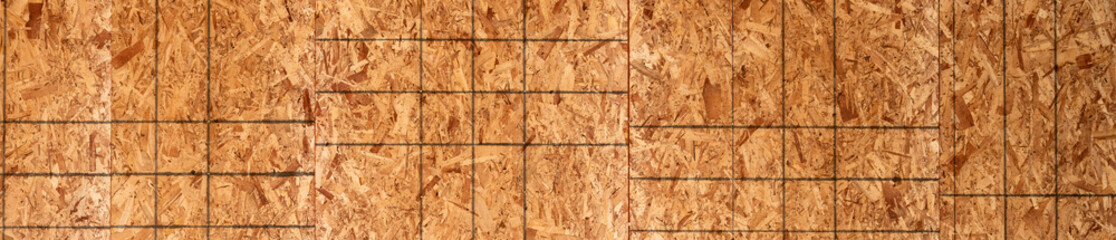 New residential home construction in framing stage, graphic detail of OSB, oriented strand board, sheathing on interior wall, summer construction season
