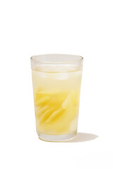 A glass of iced young mango setup, made with thinly sliced tangy yellow mango, sweetened with sugar water, pandan, cinnamon, and a hint of salt. Photographed with a white background.