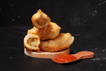 Fried stuffed Cireng, a traditional Indonesian snack filled with seasoned beef fat or jando, perfect with chili sauce dip, photographed against a dark background.