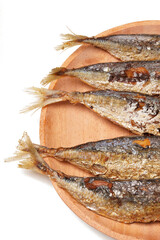 Fried Gereh Keranjang (pindang keranjang) fish, a traditional Indonesian side dish, served on a wooden plate and photographed with a white background.