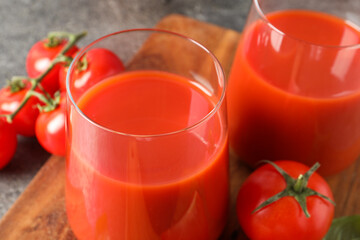 Tasty tomato juice in glasses and fresh vegetables on table, closeup