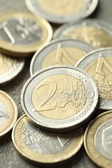 Many euro coins on grey table, closeup