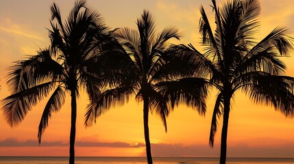 Obraz premium Silhouettes of palm trees against a vibrant orange and yellow sunset over a calm ocean.