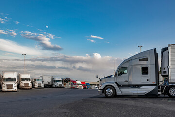 Gray big rig semi truck with refrigerator semi trailer standing for truck driver rest on the truck...
