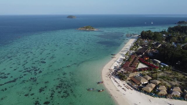 Panoramic view of Koh Lipe and Koh Adang with turquoise water, coral reef and white sand beach, with long tail boats on a sunny day in this paradise island in the south of Thailand