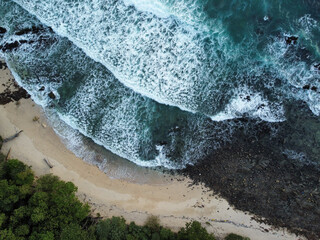 Waves breaking on rocky beach in Koh Kradan during a stormy day the rainy season, Trang, Thailand