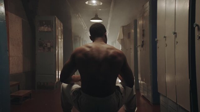 Black boxer sitting on a bench in the locker room