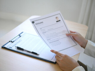 Business woman employer holds resume of job applicant to analyze data before job interviews. Regarding personnel recruitment